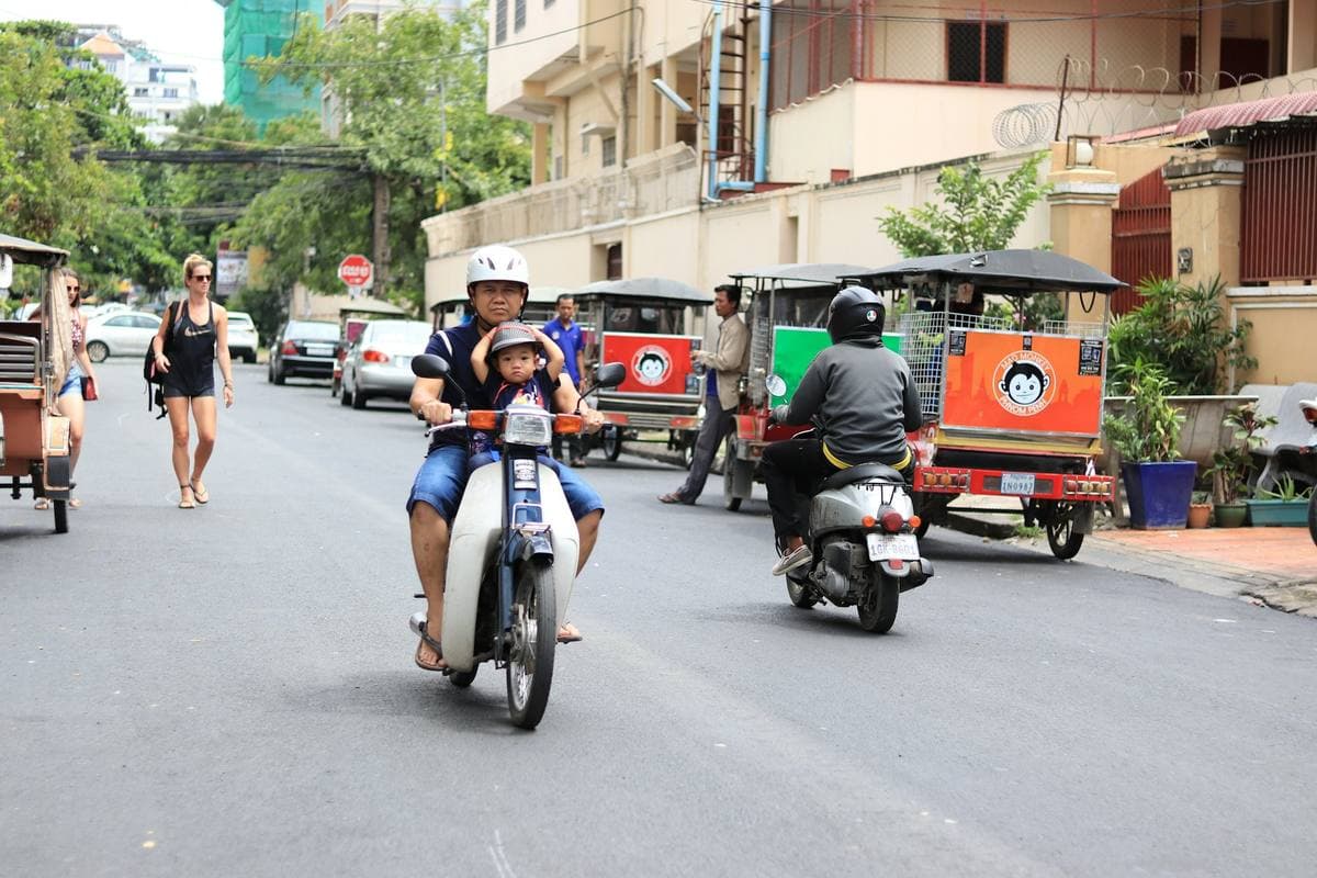 A Phnom Penh street, scooters and tuk-tuks passing